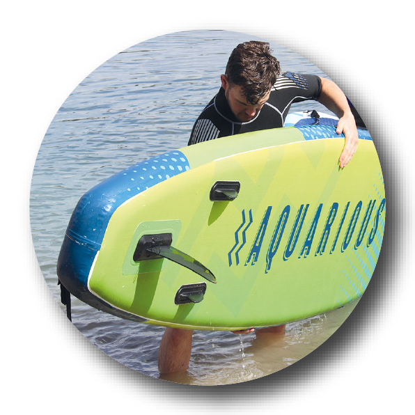 Man carrying paddleboard put of the water 